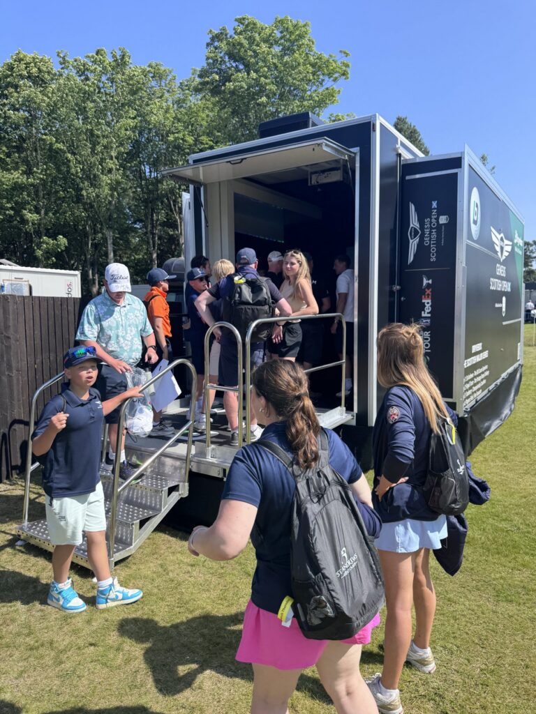 Visitors queuing to try the Dryvebox mobile golf simulator at a UK golf event